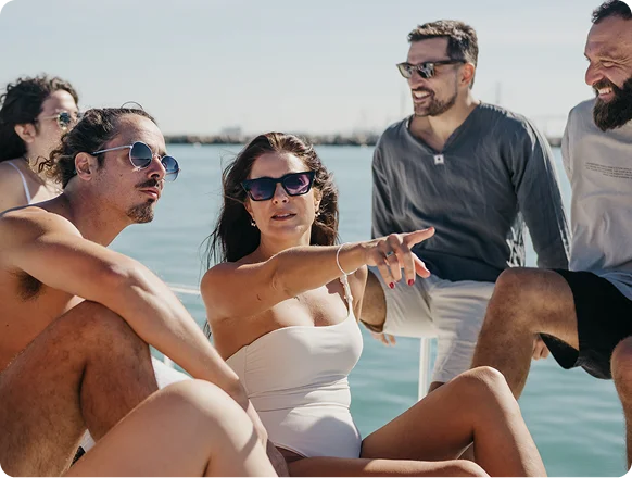 Grupo de amigos relajándose y disfrutando durante un paseo en barco en Cádiz bajo el sol